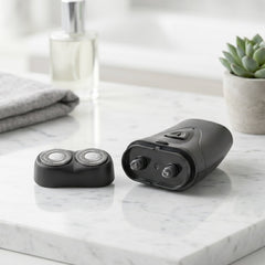 Portable electric shaver in hand showing compact size and sleek design