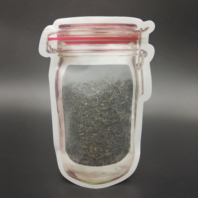 A jar-shaped zipper pouch filled with loose green tea leaves is displayed on a dark background.