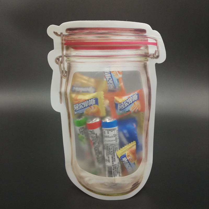 A jar-shaped zipper pouch filled with various small candies and snacks sits on a dark background.
