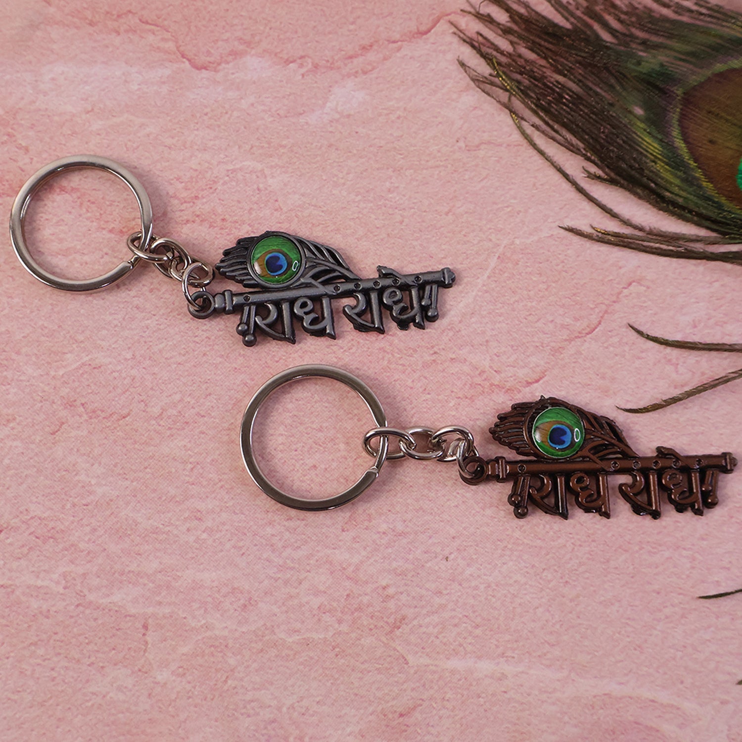 Top view of Radhe Radhe copper finish keychain with vibrant peacock feather