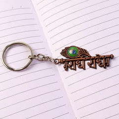 Radhe Radhe metal keychain showing flute and peacock feather spiritual details