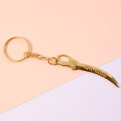 Side view of golden sword style metal keychain with intricate detailing