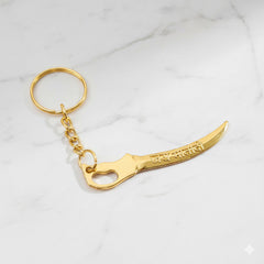 Close-up of curved sword design on golden Mataji devotional keychain