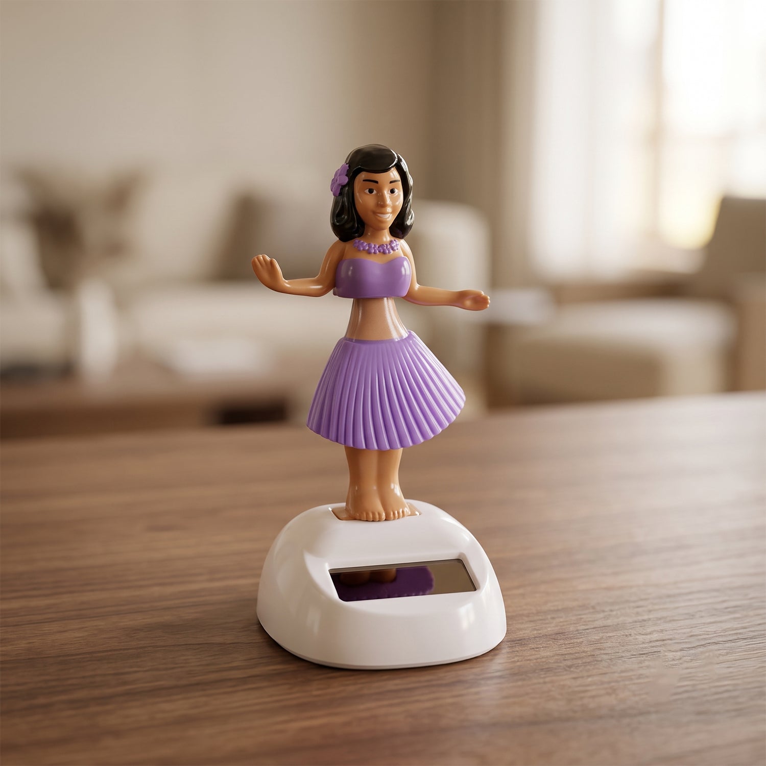 A solar-powered dancing hula girl toy in purple and brown, with a white base, on a wooden table indoors.