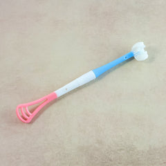 A blue, white, and pink baby tongue cleaner and toothbrush with a textured white handle and a pink scraper end.