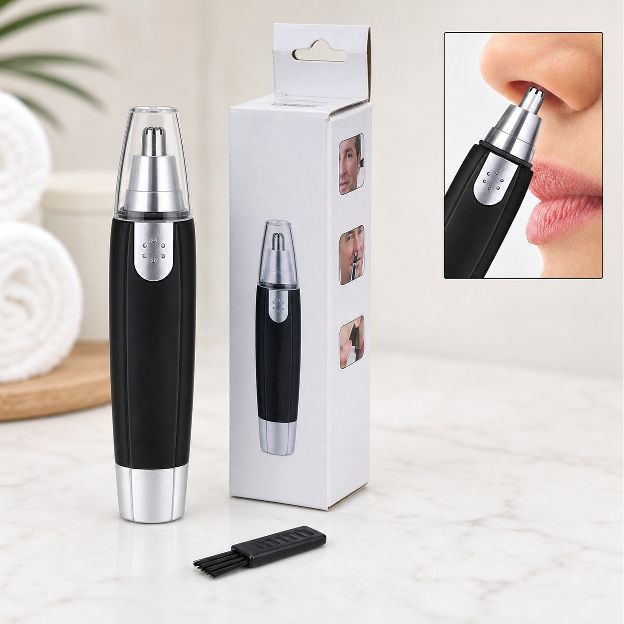 A black and silver nose hair trimmer stands next to its white box, with a small cleaning brush.