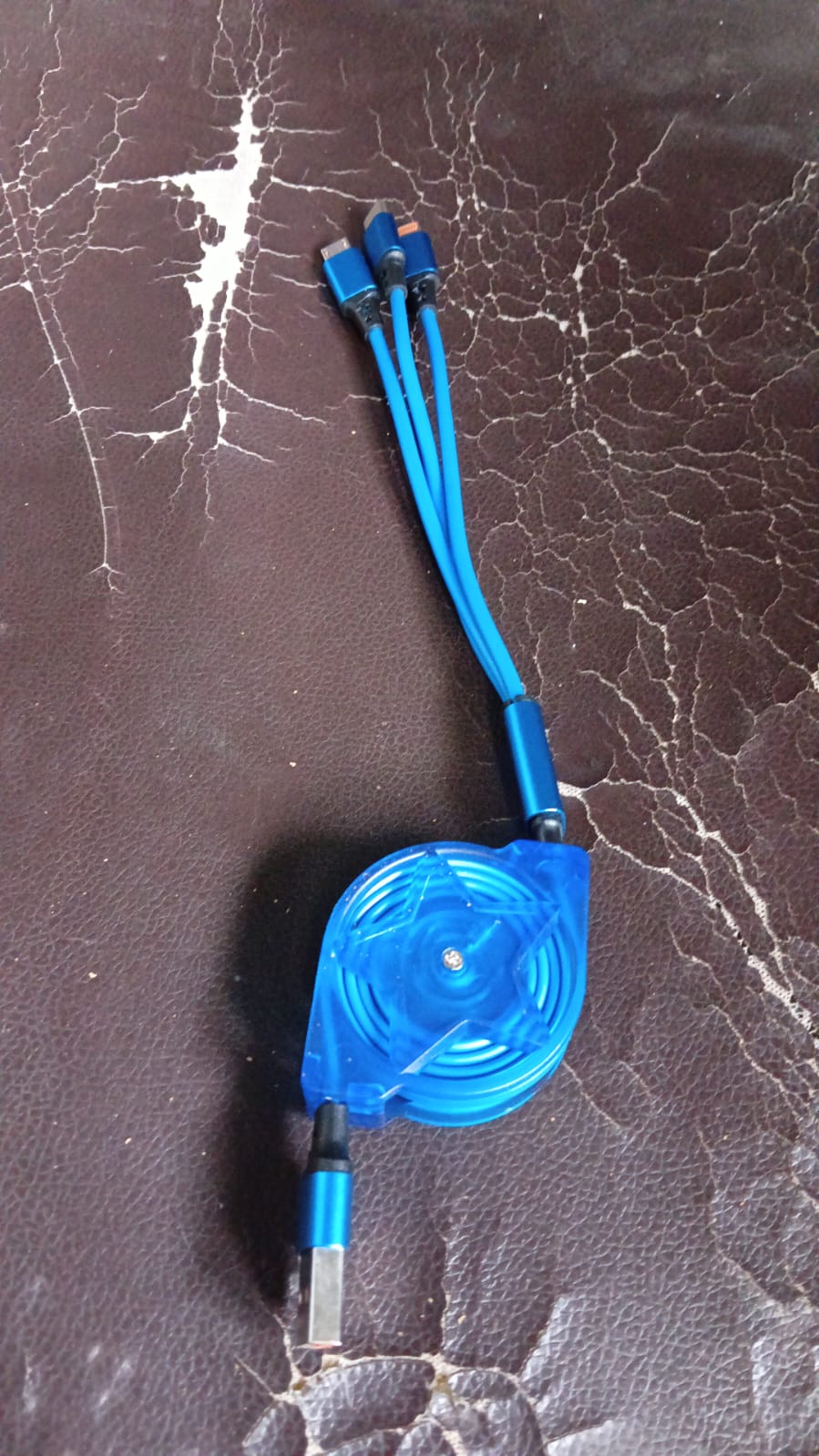The 3-in-1 retractable charging cable shown with various compatible mobile devices.