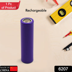 A single purple rechargeable battery stands upright on a light surface with tools in the background.