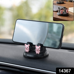 A black phone holder with two pink pig figurines on a car dashboard, holding a smartphone horizontally.