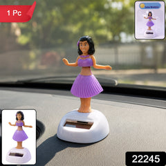 A solar-powered dancing hula girl toy in purple and brown, with a white base, on a car dashboard.